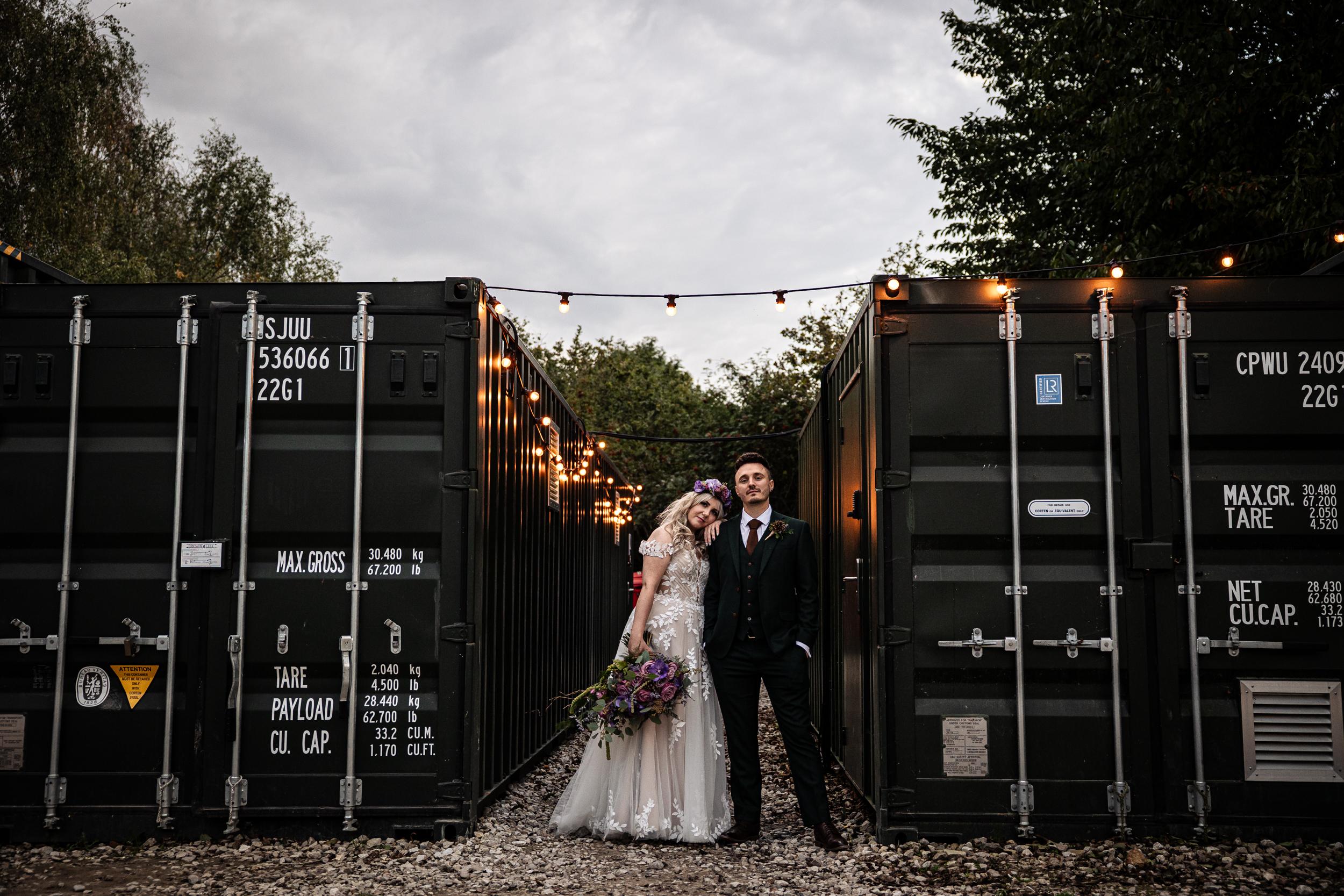 Couple surrounded by shipping containers at their Royle Forest Wedding taken by Assassynation Alternative Wedding Photography